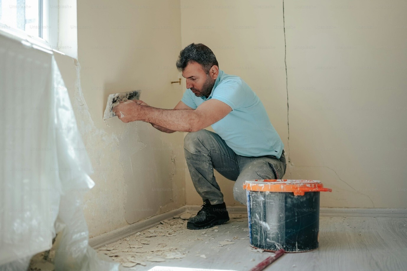 Man plastering a wall with a trowel